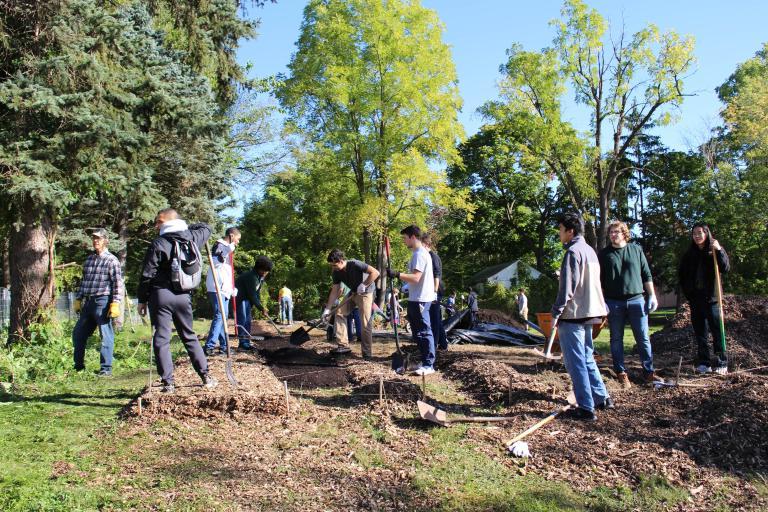 正规的赌博app students rake mulch in an area park.